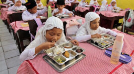 Siswa menyantap makan bergizi gratis di Sekolah Madrasah Ibtidaiyah Negeri Medan, Sumatera Utara, Rabu (14/1/2026).
