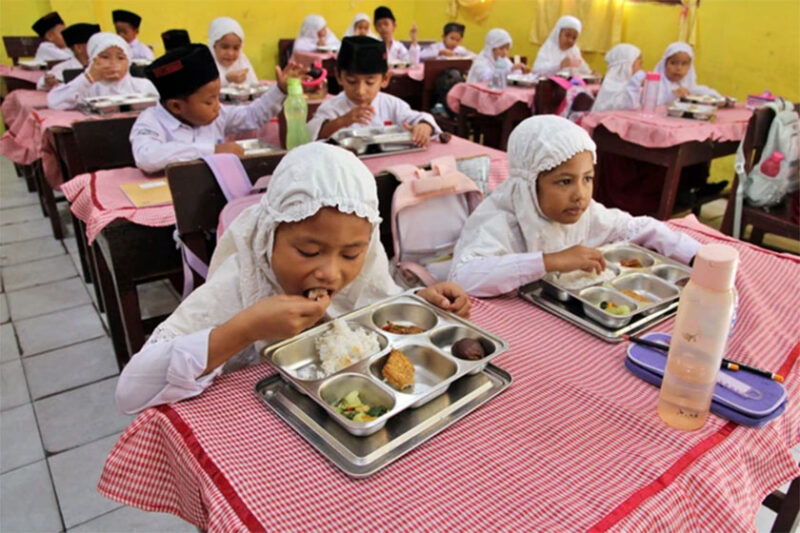 Siswa menyantap makan bergizi gratis di Sekolah Madrasah Ibtidaiyah Negeri Medan, Sumatera Utara, Rabu (14/1/2026).
