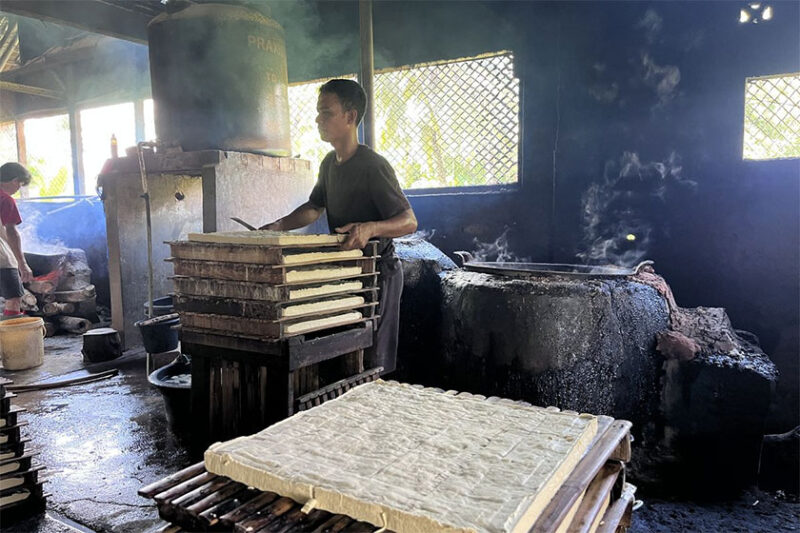 Seorang pegawai menunjukkan proses pembuatan tahu di pabrik tahu, Paledah, Padaherang, Kabupaten Pangandaran, Senin (18/5/2026). KOMPAS.COM/ AYU SABRINA BAROKAH(Ayu Sabrina Barokah )
