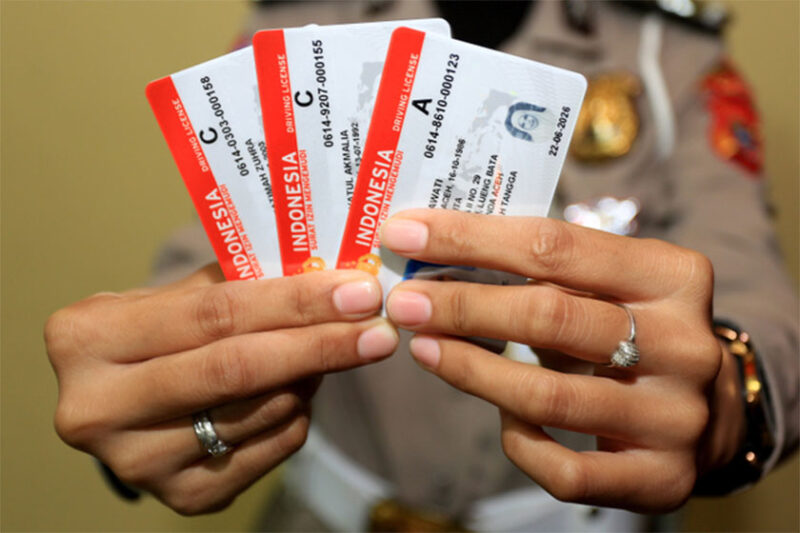 Petugas menunjukkan Surat Izin Mengemudi (SIM) seusai proses pembuatan di Kantor Satuan Penyelenggara Administrasi SIM. Foto: ANTARA FOTO/Syifa Yulinnas
