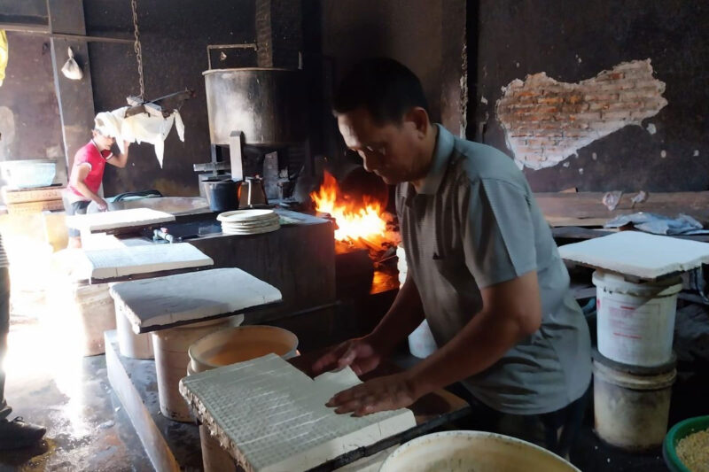 Pengrajin tahu asal Banyuwangi, Nurul Hakim saat memproduksi tahu di tempat usahanya.(KOMPAS.COM/Fitri Anggiawati)
