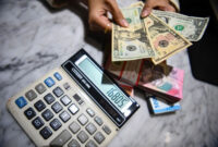 Petugas menunjukkan pecahan mata uang dolar Amerika Serikat dan mata uang Rupiah di Kantor Cabang BNI Pasar Baru, Jakarta, Selasa (10/3/2026). Foto: Muhammad Adimaja/ANTARA FOTO
