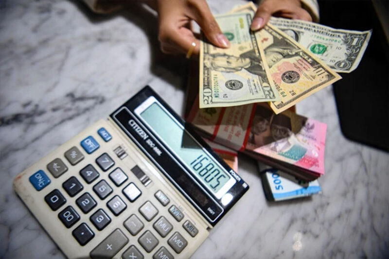 Petugas menunjukkan pecahan mata uang dolar Amerika Serikat dan mata uang Rupiah di Kantor Cabang BNI Pasar Baru, Jakarta, Selasa (10/3/2026). Foto: Muhammad Adimaja/ANTARA FOTO
