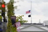 Bendera Amerika berkibar setengah tiang di atas Gedung Putih di Washington DC, Jumat, 16 April 2021. (AP PHOTO/SUSAN WALSH)