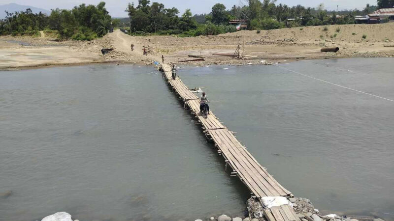 Sejumlah warga melintas dengan sepeda motor diatas jembatan kayu menghubungkan Desa Gunci dan Desa Sawang, Kabupaten Aceh Utara, Provinsi Aceh, Sabtu (30/5/2026).(KOMPAS.COM/MASRIADI SAMBO)