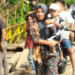 Seorang ibu menggendong anaknya saat melintas di jembatan gantung Desa Talang Buai, Kabupaten Mukomuko, Bengkulu.(Asril)
