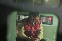 Komisaris PT YAT, Andri Mulyono atau AM (tertunduk lesu) dalam mobil tahanan Kejaksaan Agung usai ditetapkan tersangka kasus dugaan korupsi tata kelola program Makan Bergizi Gratis (MBG) di Badan Gizi Nasional (BGN) periode 2025-2026, Jumat (12/6/2026).(KOMPAS.com/NICHOLAS RYAN ADITYA)
