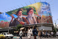 Baliho bergambar mantan Pemimpin Tertinggi Iran, Ayatollah Ruhollah Khomeini (kiri) dan yang baru saja meninggal Ayatollah Ali Khamenei (kanan) dipasang di Teheran, Iran, 8 Juni 2026.(AFP/ATTA KENARE)
