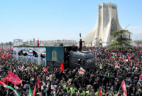 Lautan manusia memadati jalanan untuk melihat langsung peti mati mendiang Pemimpin Tertinggi Iran Ayatollah Ali Khamenei, saat jenazahnya melewati Menara Azadi di Teheran, Senin (6/7/2026).(AFP/WAKIL KOHSAR)