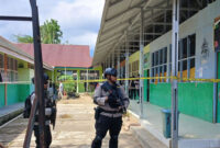 Personel Brimob Polda Sumatera Barat berjaga di lokasi ledakan yang diduga berasal dari bom rakitan di MAN 3 Kota Padang, Kelurahan Balai Gadang, Kecamatan Koto Tangah, Kota Padang, Selasa (14/07/2026). Polisi melakukan sterilisasi dan olah tempat kejadian perkara, sementara seorang siswa yang diduga membawa bom rakitan diamankan untuk menjalani pemeriksaan.(KOMPAS.com/DHARMA HARISA)