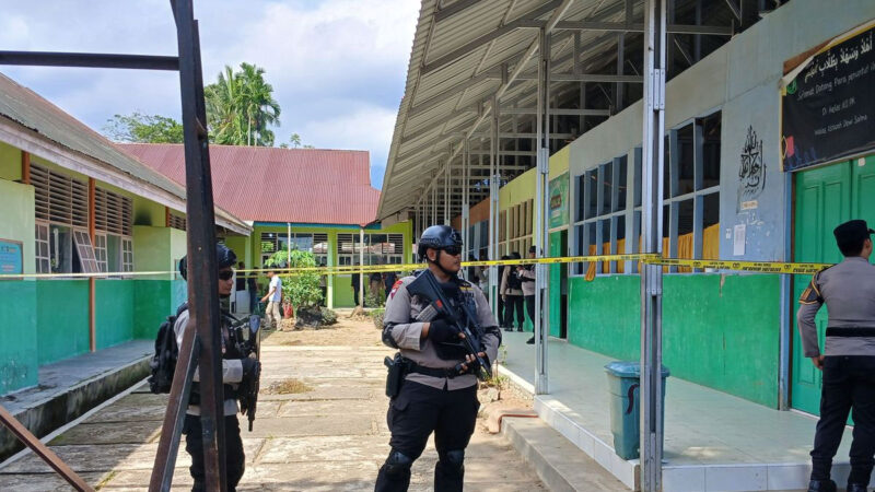 Personel Brimob Polda Sumatera Barat berjaga di lokasi ledakan yang diduga berasal dari bom rakitan di MAN 3 Kota Padang, Kelurahan Balai Gadang, Kecamatan Koto Tangah, Kota Padang, Selasa (14/07/2026). Polisi melakukan sterilisasi dan olah tempat kejadian perkara, sementara seorang siswa yang diduga membawa bom rakitan diamankan untuk menjalani pemeriksaan.(KOMPAS.com/DHARMA HARISA)
