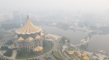 Kabut asap menyelimuti kawasan sekitar Gedung Dewan Undangan Negeri Sarawak di Kuching, ibu kota Negara Bagian Sarawak, Malaysia, pada 1 September 2026. Kualitas udara di Sarawak memburuk akibat asap dari kebakaran hutan di Indonesia, yang turut memicu gangguan pernapasan dan membuat warga menggunakan masker pelindung. (AFP)
