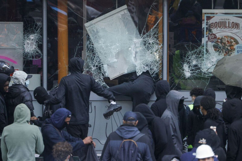 Pedemo Perancis memecahkan jendela toko makanan milik perusahaan Picard dalam aksi unjuk rasa memprotes kenaikan biaya hidup di Paris, Sabtu (17/10/2026).(AFP/GEOFFROY VAN DER HASSELT)
